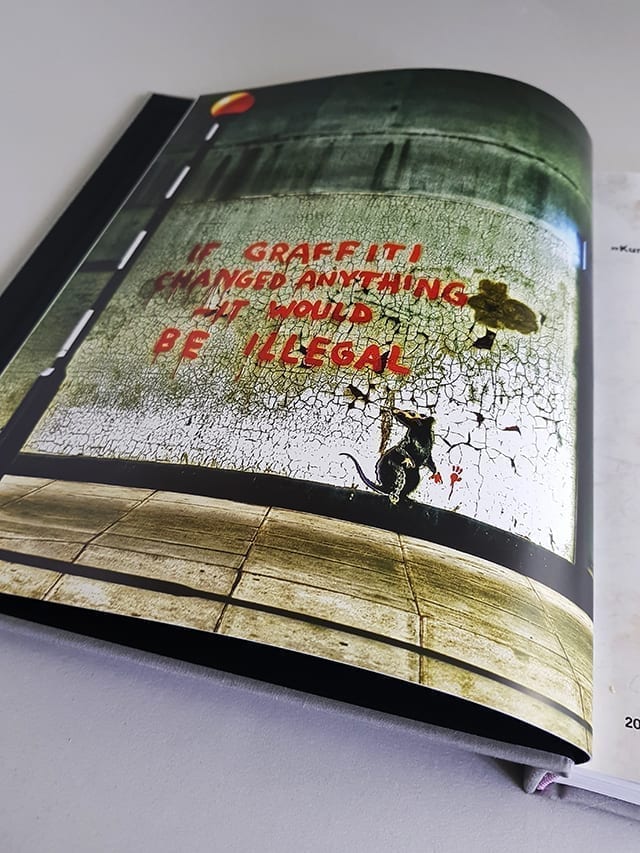 Banksy Provokation Midas Verlag aufgeschlagener Bildband