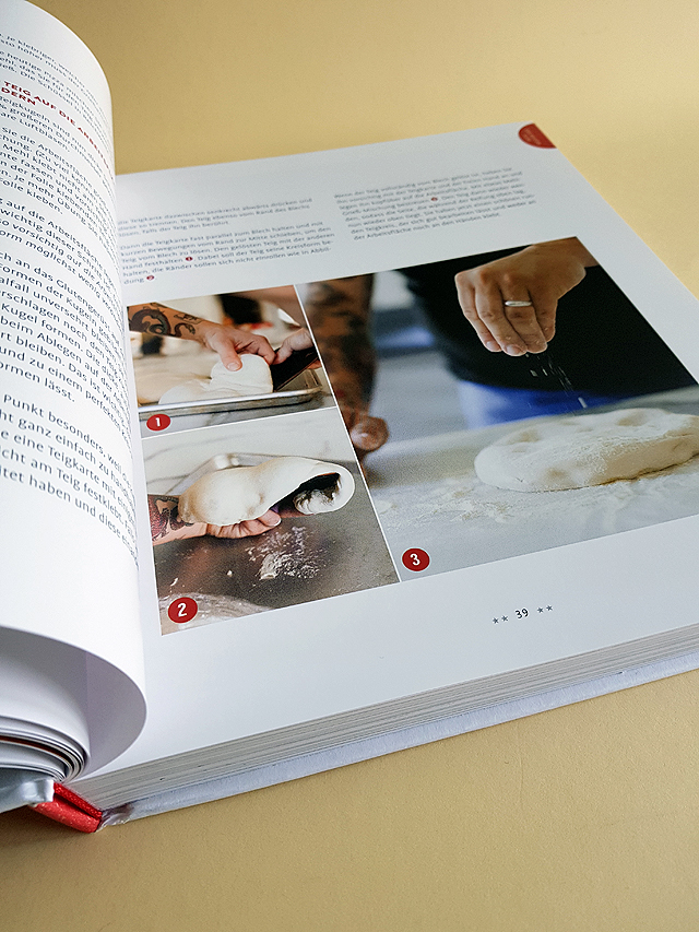 Aufgeschlagene rechte Buchseite des Buches "Die Pizza Bibel". Drei Fotos stellen dar, wie der Teig geknetet wird, darüber befindet sich ein informativer Text zum Backen der Pizza.