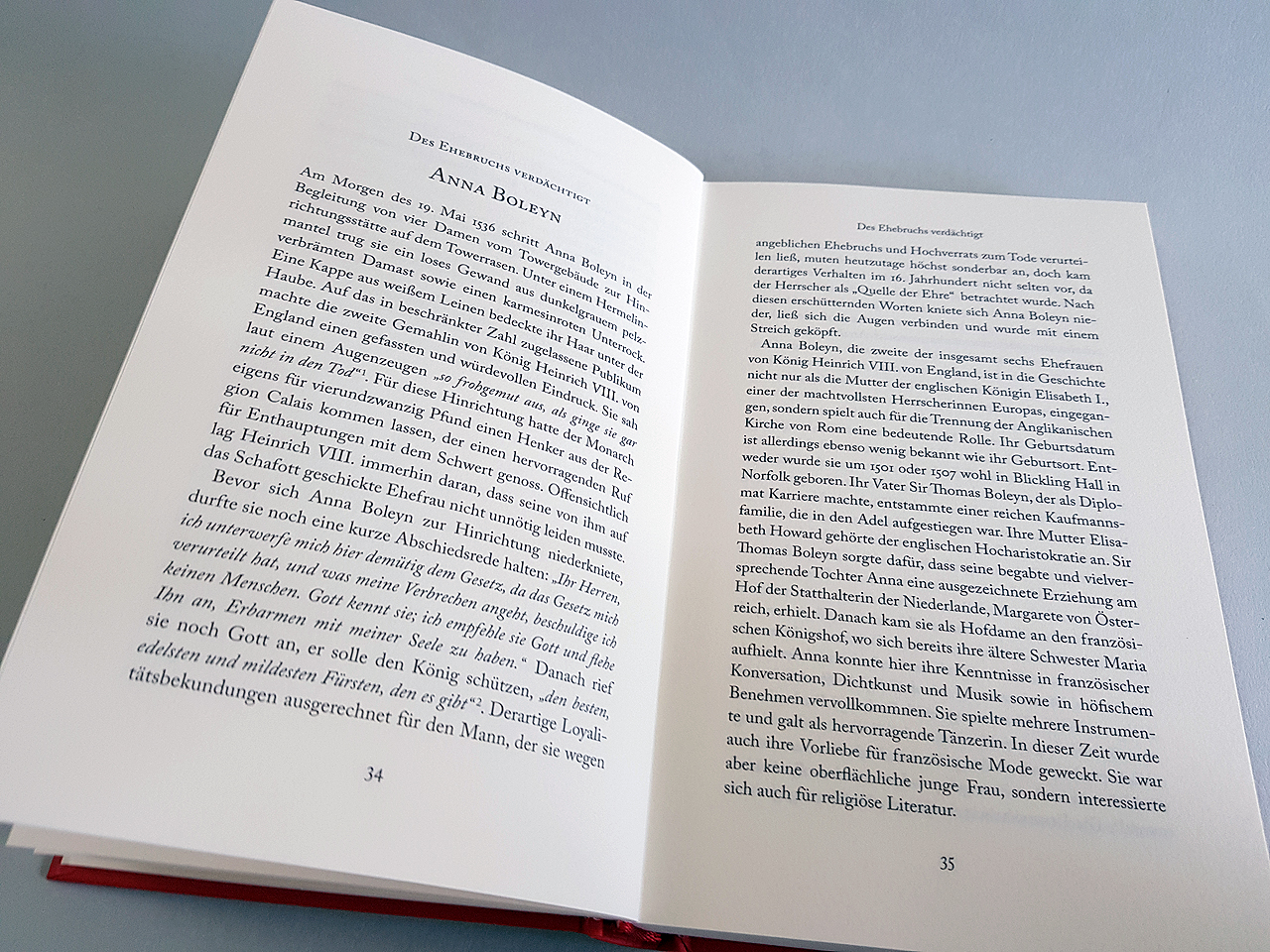 Doppelseite des Sachbuchs ‚Legendäre Frauen. Zwischen Triumph und Verhängnis‘ von Barbara Beck. Aufgeschlagen sind die ersten Seiten des Kapitels zu Anna Boleyn. Unter den Seiten ist der rote Umschlag der Hardcover Bindung zu erkennen.